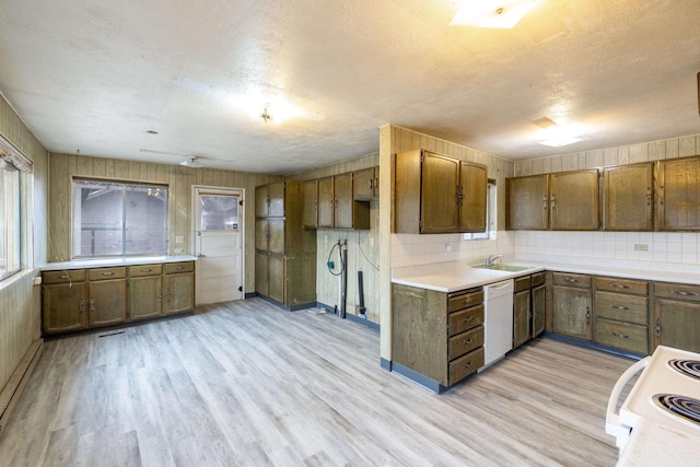 kitchen with light hardwood / wood-style floors, electric range, sink, white dishwasher, and a textured ceiling