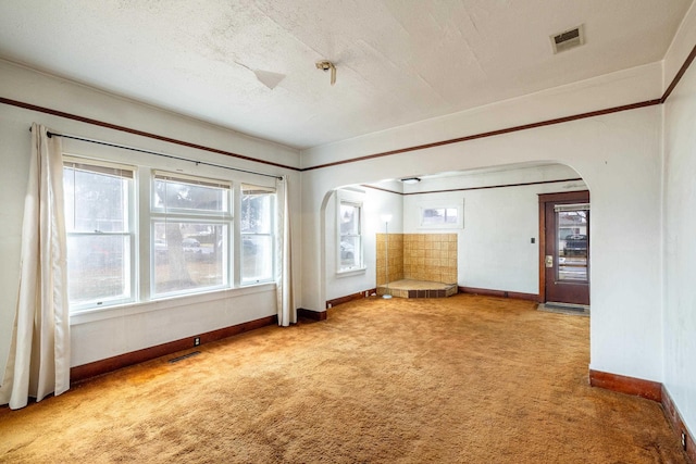 unfurnished living room featuring carpet floors and a textured ceiling