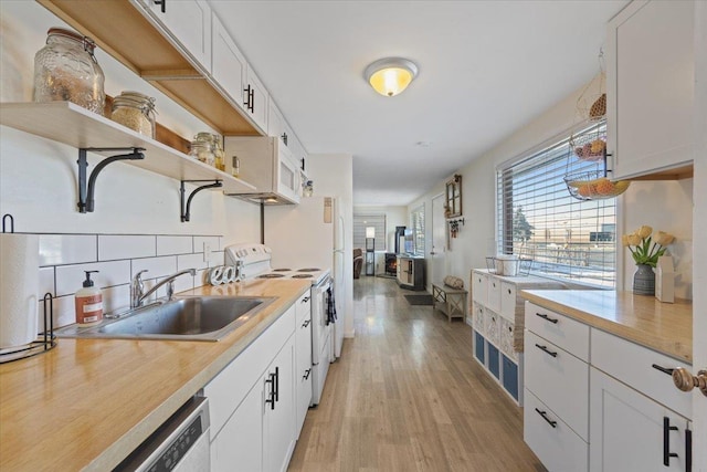 kitchen with white cabinetry, light hardwood / wood-style flooring, sink, backsplash, and white appliances