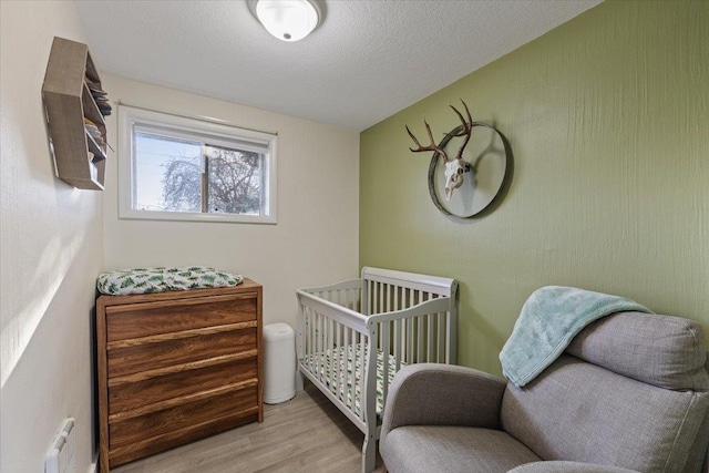 bedroom featuring light hardwood / wood-style floors and a textured ceiling