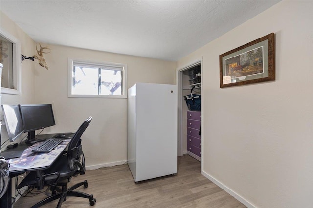 office area featuring light hardwood / wood-style floors and a textured ceiling