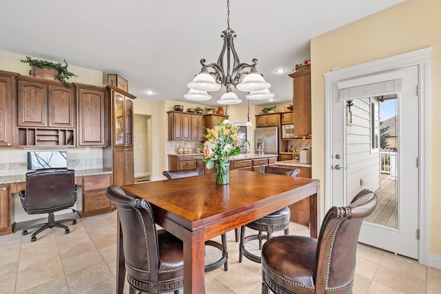 dining area featuring a chandelier and built in desk