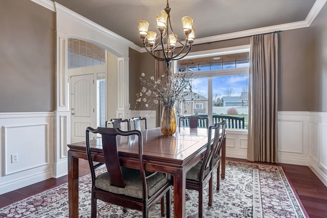 dining space featuring dark wood-type flooring, a chandelier, and crown molding