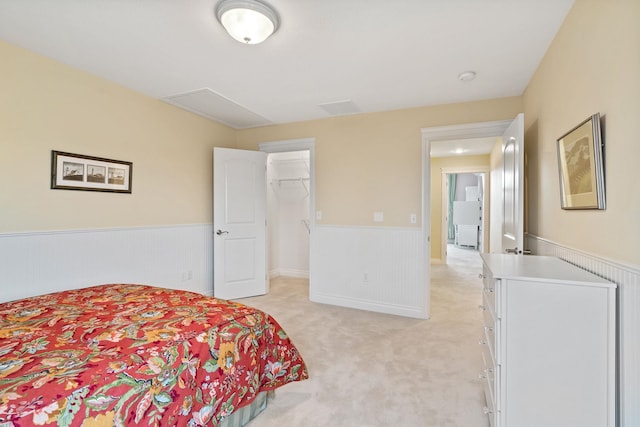 bedroom with light carpet, a closet, and a spacious closet