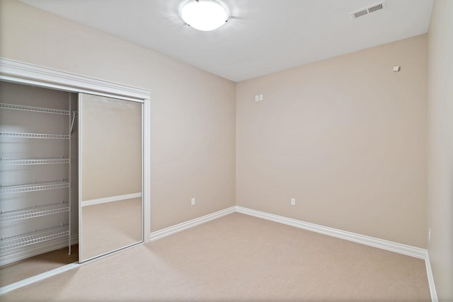 unfurnished bedroom with a closet and carpet flooring