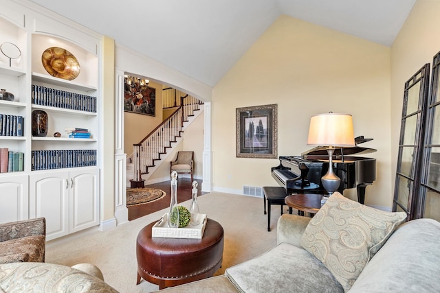 carpeted living room featuring built in features and vaulted ceiling