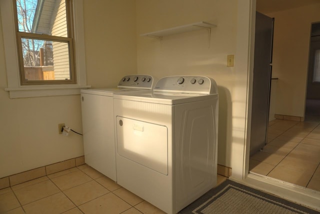 clothes washing area featuring light tile patterned floors and independent washer and dryer