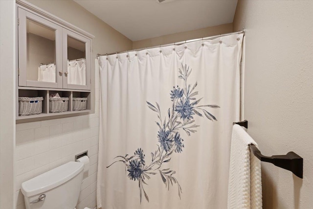 bathroom featuring tile walls and toilet