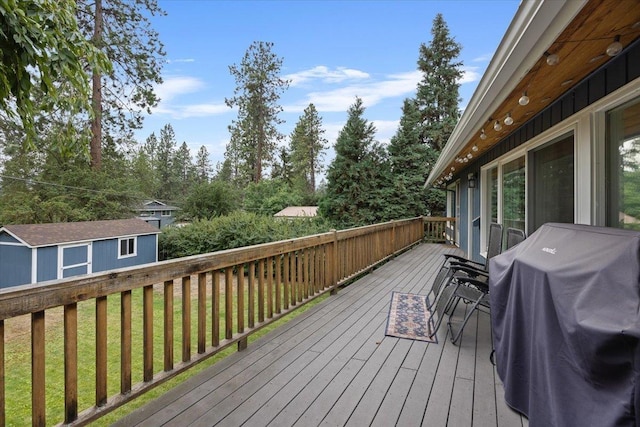 deck with a lawn, grilling area, and a shed