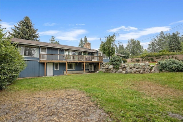 rear view of property with a wooden deck and a lawn