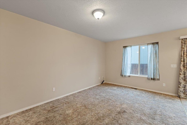 spare room featuring carpet floors and a textured ceiling