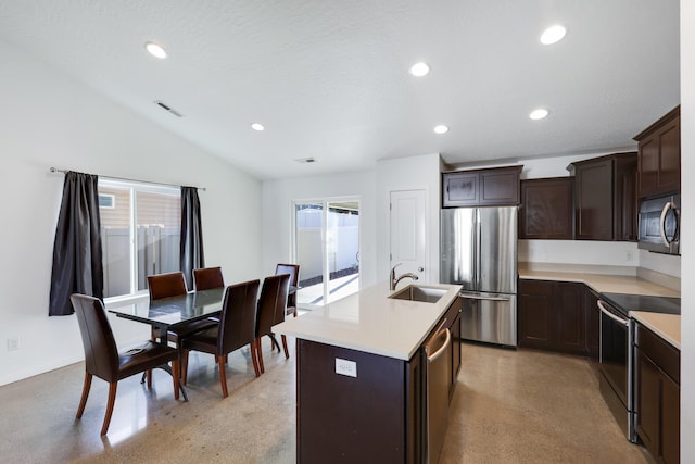 kitchen featuring dark brown cabinets, vaulted ceiling, sink, a kitchen island with sink, and stainless steel appliances