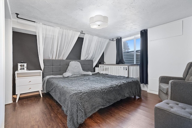 bedroom with dark wood-type flooring and a textured ceiling