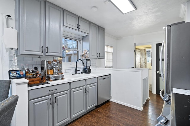 kitchen with gray cabinetry, sink, and stainless steel appliances