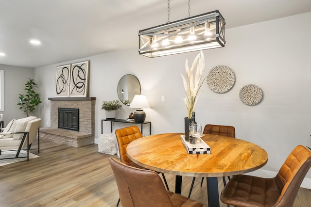 dining area with hardwood / wood-style flooring and a fireplace