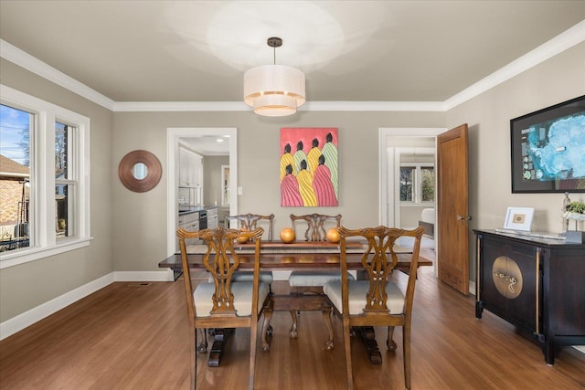 dining area with wood-type flooring and ornamental molding