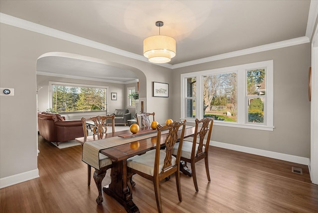 dining area featuring crown molding and dark hardwood / wood-style flooring