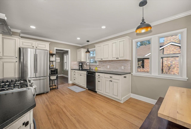 kitchen featuring sink, decorative light fixtures, dishwasher, and stainless steel fridge