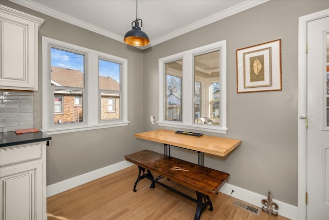 dining space featuring crown molding and light wood-type flooring