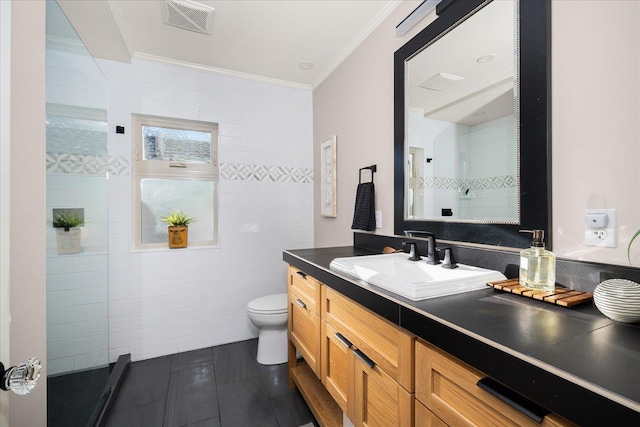 bathroom with crown molding, tile patterned floors, vanity, toilet, and a tile shower