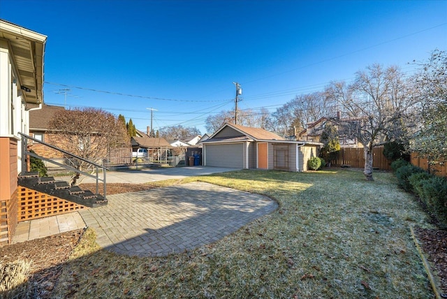 view of yard with a patio, an outbuilding, and a garage