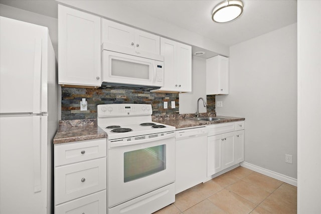 kitchen with white appliances, white cabinetry, light tile patterned floors, sink, and backsplash