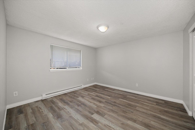 unfurnished room featuring a textured ceiling, baseboard heating, and dark wood-type flooring