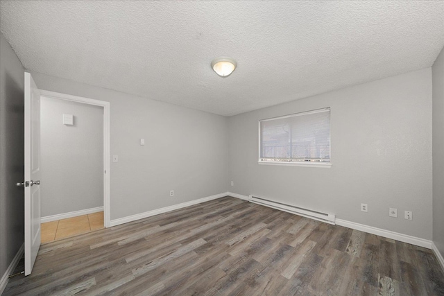 unfurnished room with dark wood-type flooring, a baseboard radiator, and a textured ceiling