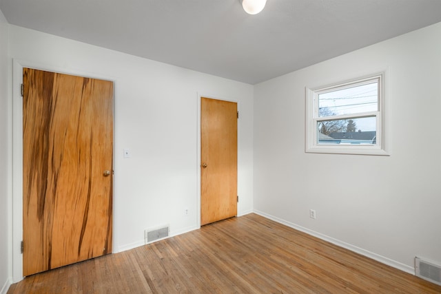 unfurnished bedroom featuring light hardwood / wood-style flooring and a closet