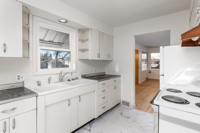 kitchen with sink, white appliances, white cabinets, and a healthy amount of sunlight