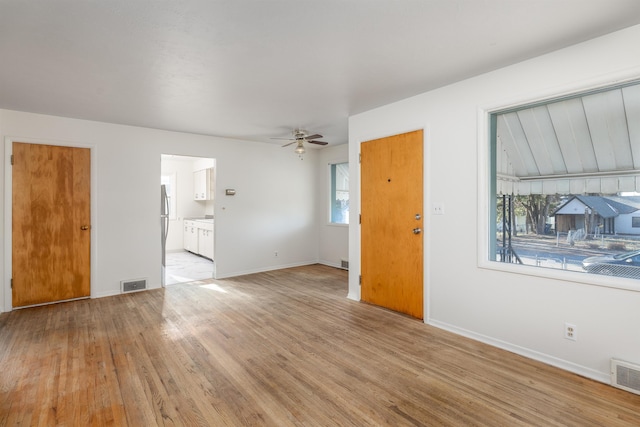 unfurnished living room with ceiling fan and light wood-type flooring