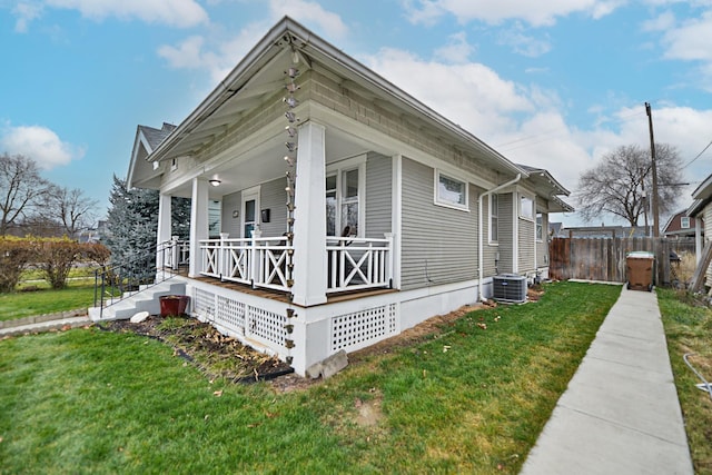 view of home's exterior featuring central AC unit, a lawn, and a porch