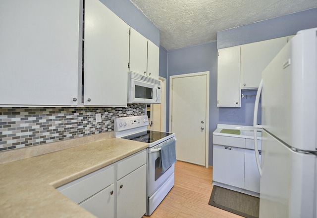 kitchen featuring decorative backsplash, white appliances, white cabinets, and a textured ceiling