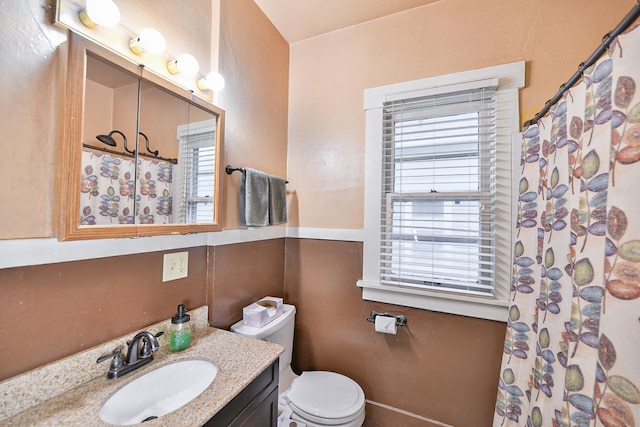 bathroom with toilet, vanity, and a shower with curtain