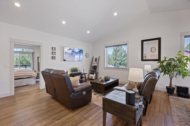 living room featuring light wood-type flooring, a wealth of natural light, and lofted ceiling