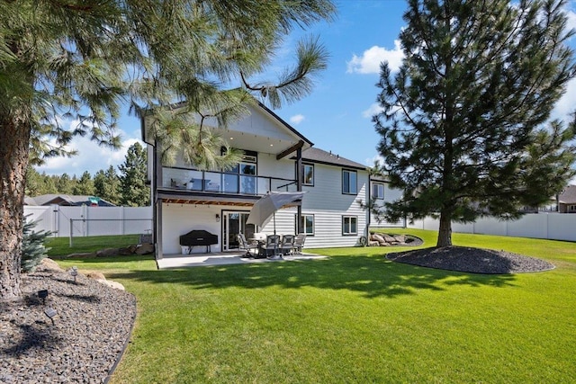 rear view of house with a patio area and a lawn