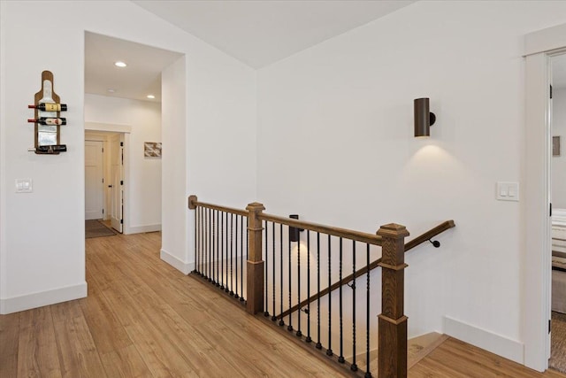 hall with lofted ceiling and light wood-type flooring