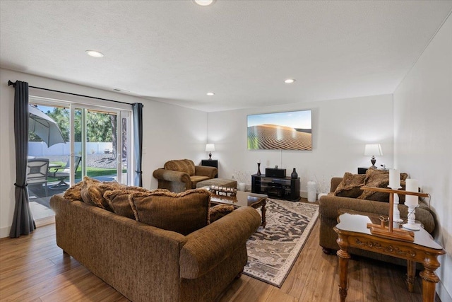 living room featuring light hardwood / wood-style floors and a textured ceiling