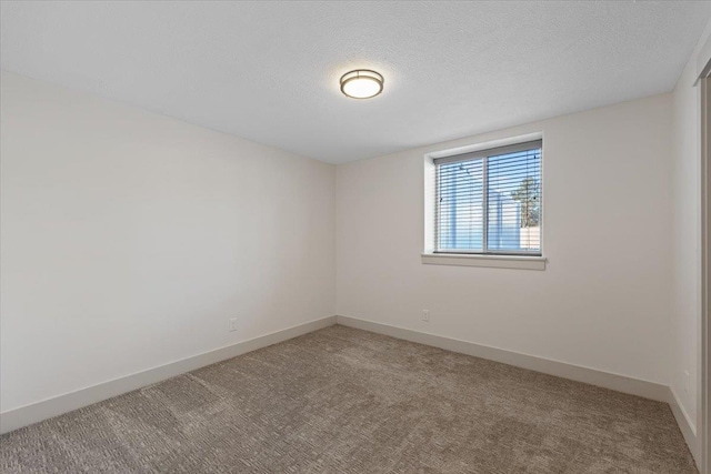 carpeted empty room with a textured ceiling