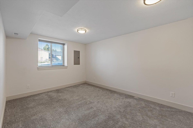 carpeted empty room featuring electric panel and a textured ceiling