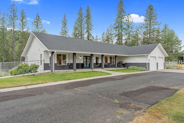 ranch-style home featuring a porch, a garage, and a front lawn