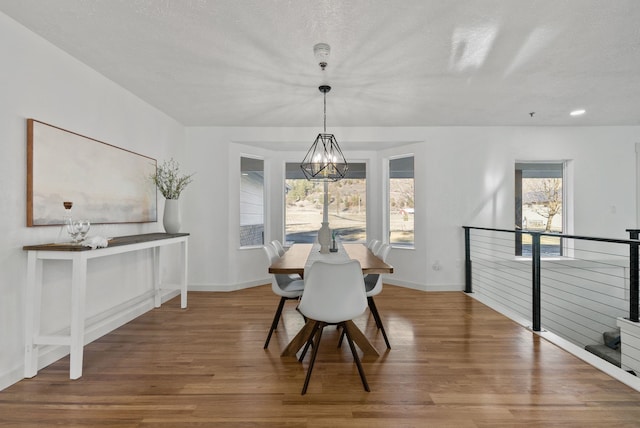 dining room featuring hardwood / wood-style flooring, a textured ceiling, and a chandelier