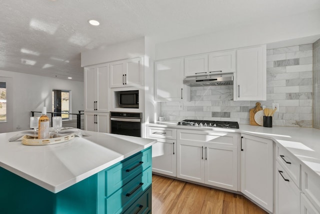 kitchen featuring a center island, white cabinetry, light hardwood / wood-style flooring, and appliances with stainless steel finishes