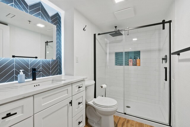 bathroom featuring hardwood / wood-style floors, a shower with door, decorative backsplash, and vanity