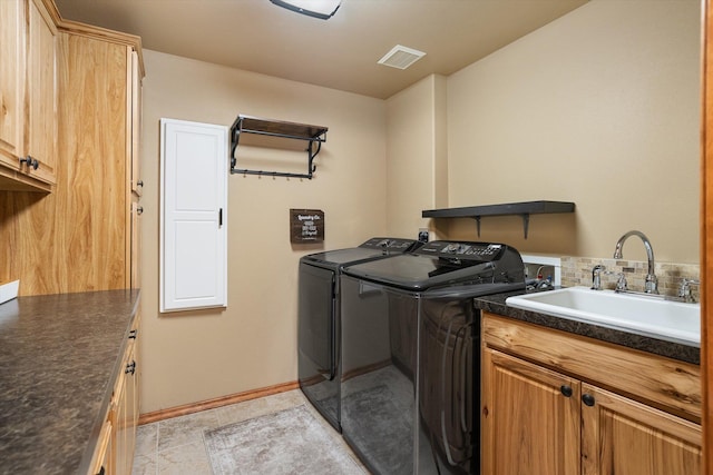 washroom with sink, cabinets, and separate washer and dryer