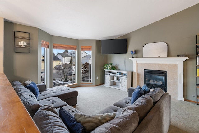 carpeted living room featuring a tile fireplace