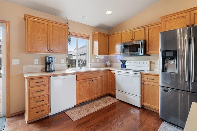 kitchen with sink, appliances with stainless steel finishes, dark hardwood / wood-style floors, and lofted ceiling