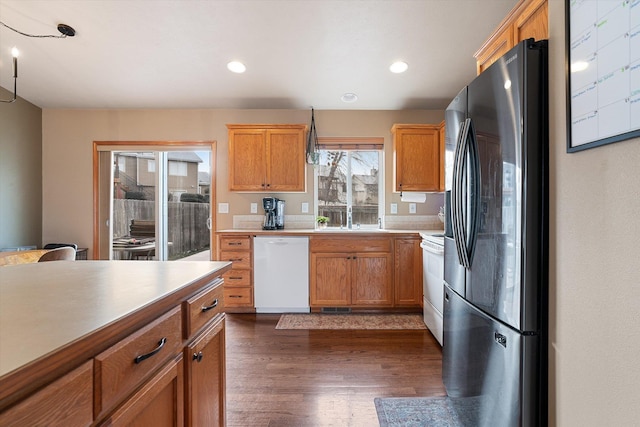 kitchen with sink, white appliances, and dark hardwood / wood-style flooring