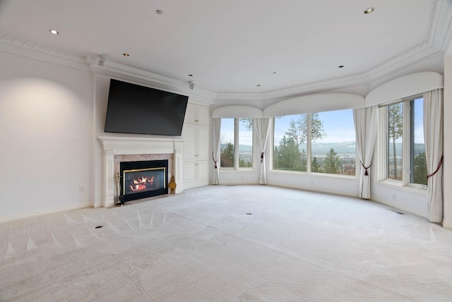 unfurnished living room featuring light colored carpet, crown molding, and a premium fireplace