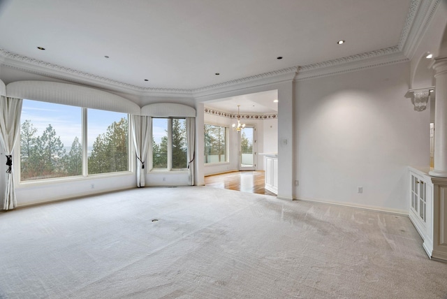 unfurnished living room with crown molding, light colored carpet, a chandelier, and ornate columns